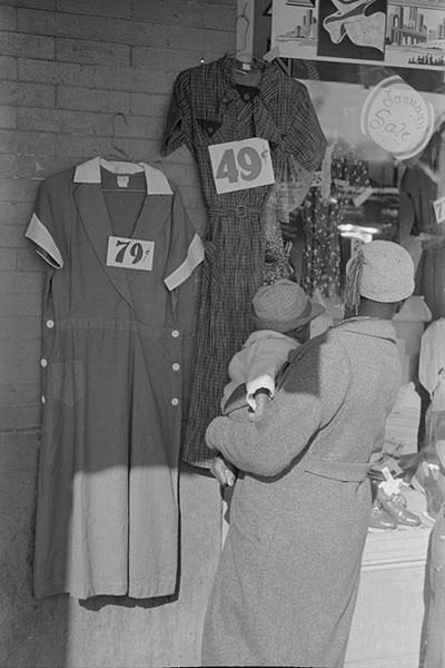 Woman examining dresses in front of shop
